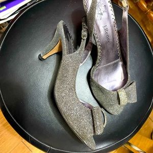 Pair of sandals, silver color, with metal decoration and crystals on the front.